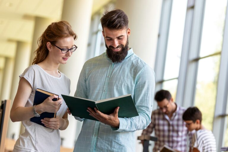 Happy group of students studying and working together in a college library